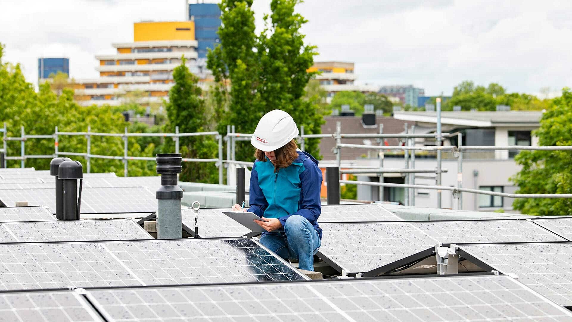 Projektleiterin Sabrina Gulde arbeitet auf einem Solarfeld auf einem Dach